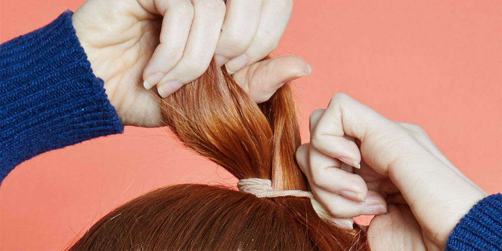 Redhead hands with headband, orange background